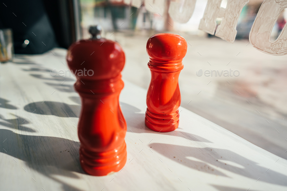 salt and pepper grinders on a table Stock Photo by simbiothy | PhotoDune