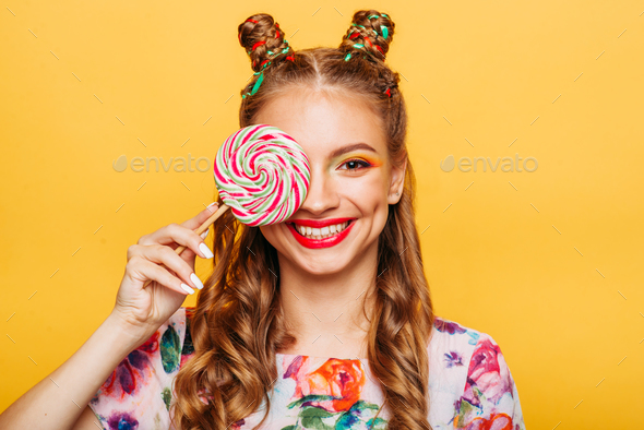 Beautiful young woman holds in hand candy Stock Photo by NomadSoul1