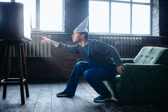 Strange man in tinfoil cap reaches out to TV, UFO Stock Photo by NomadSoul1