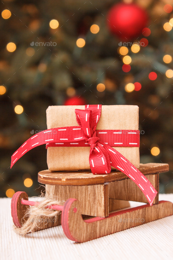 wrapped gift with ribbonon wooden sled and christmas tree with lights in background stock photo by ratmaner - Wooden Sled Decoration Christmas wrapped gift with ribbonon wooden sled and christmas tree with lights in background stock photo by ratmaner - Wooden Sled Decoration Christmas