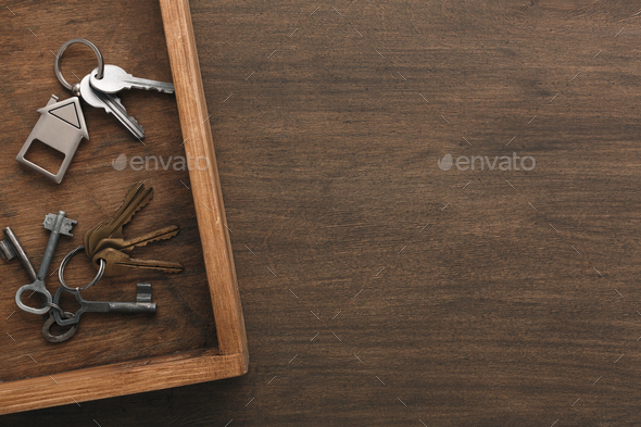 Many different keys on wooden tray Stock Photo by Milkosx | PhotoDune