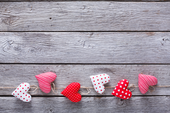 Valentine day background, pillow hearts border on wood Stock Photo by Milkosx