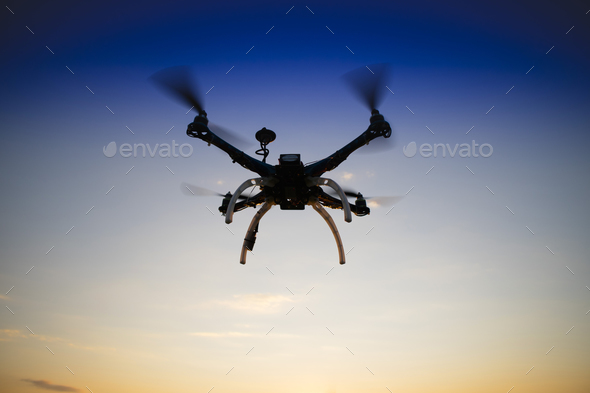 Quadrocopter in flight at sunset Stock Photo by fotografiche | PhotoDune