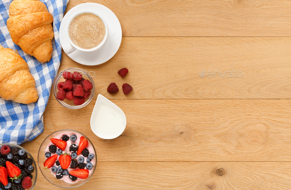 Continental breakfast with croissants and berries on natural wood Stock Photo by Milkosx