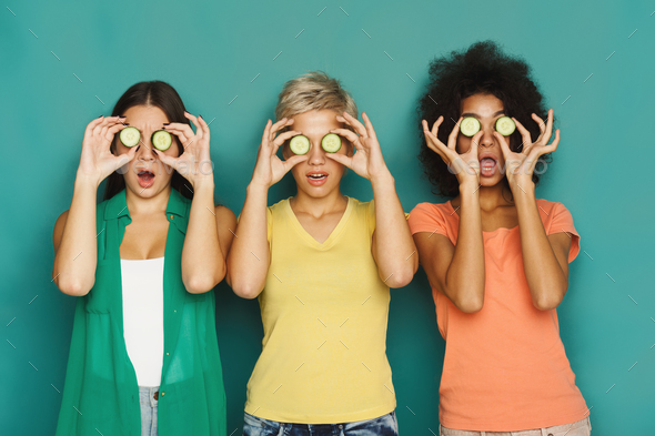 Three beautiful girls covering eyes with cucumber pieces Stock Photo by Milkosx