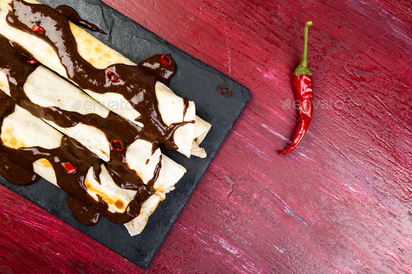 Mexican chicken enchiladas with chili chocolate salsa Stock Photo by bondarillia