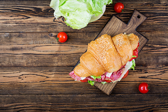 Tasty breakfast. Appetizing croissant with salami and, cheese and tomatoes. Flat lay. Top view Stock Photo by Timolina