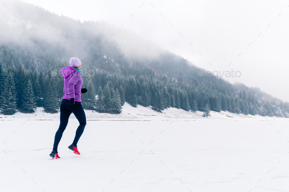 Woman running on winter trail, fitness inspiration and motivatio Stock Photo by blas