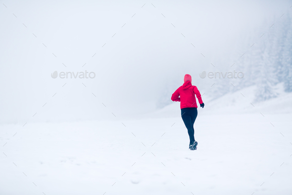Woman running on snow in winter mountains Stock Photo by blas | PhotoDune