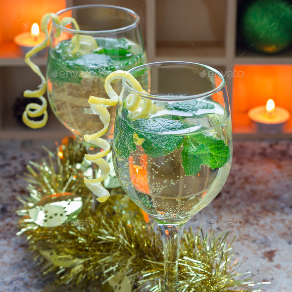 Spritzer cocktail with white wine, mint and ice, decorated with spiral lemon zest, square format Stock Photo by iuliia_n