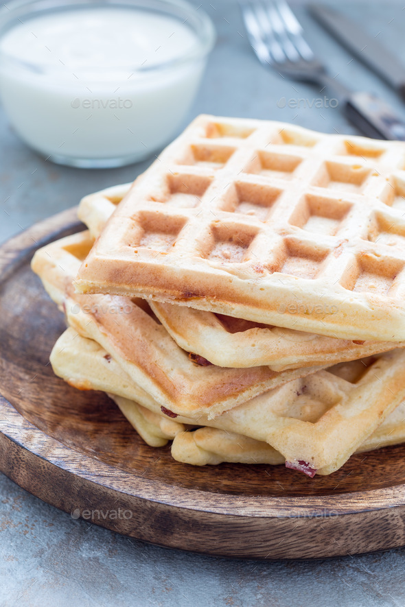 Homemade savory belgian waffles with bacon and shredded cheese, vertical Stock Photo by iuliia_n