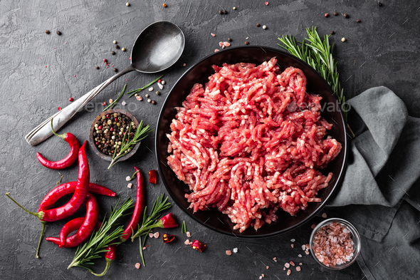Mince. Ground meat with ingredients for cooking on black background. Top view Stock Photo by sea_wave