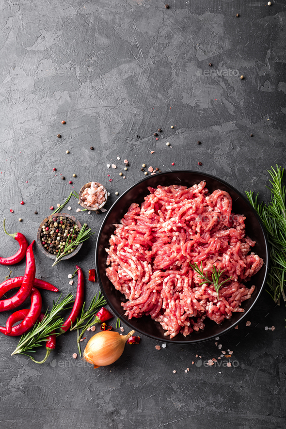Mince. Ground meat with ingredients for cooking on black background. Top view Stock Photo by sea_wave