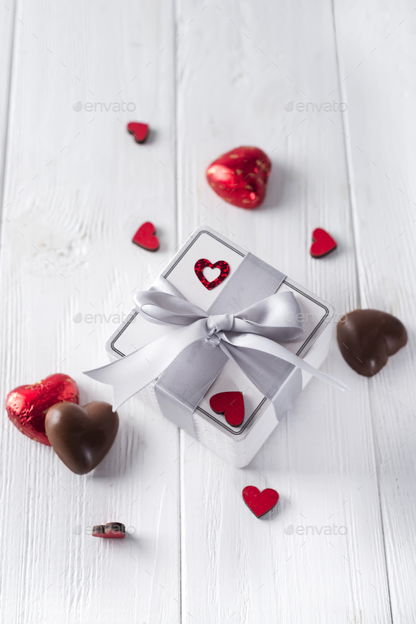 candies hearts and gift box on wooden board, Stock Photo by lyulkamazur
