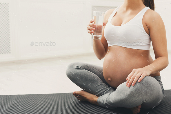 Unrecognizable pregnant woman drinking water Stock Photo by Milkosx
