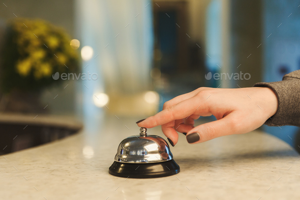 Woman ringing hotel reception service bell closeup Stock Photo by Milkosx