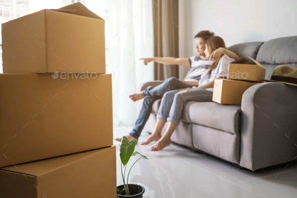 Young happy couple moving in new home, sitting and relaxing Stock Photo by kitzstocker