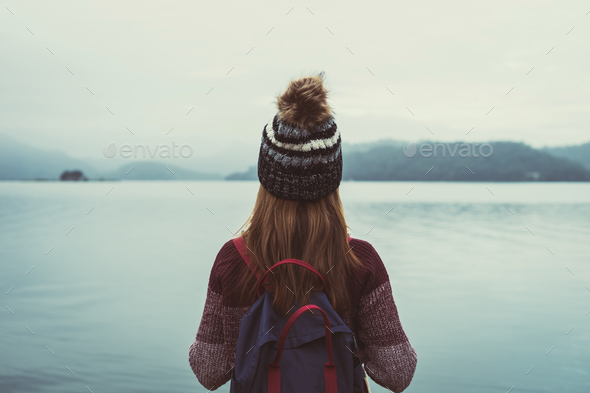 Lonely woman standing absent minded and looking at the river Stock Photo by kitzstocker