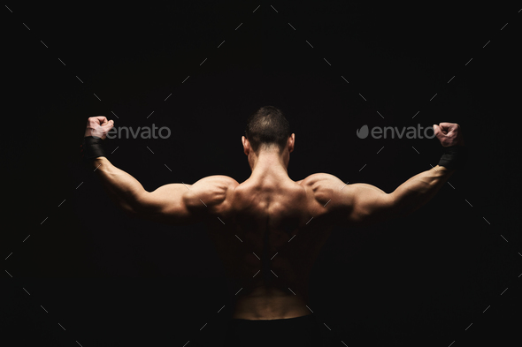 Unrecognizable man shows strong back muscles closeup Stock Photo by Milkosx