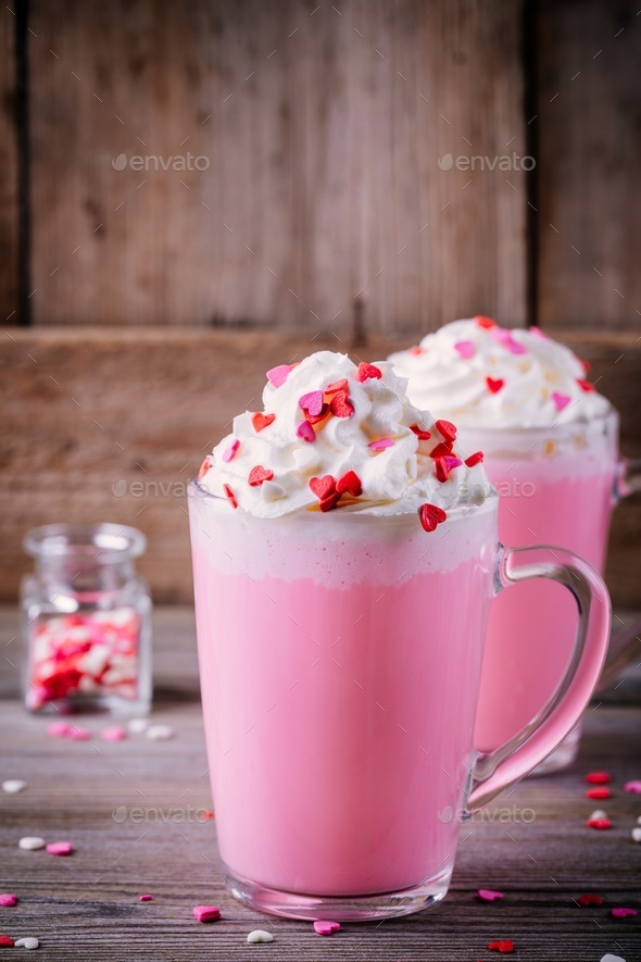 Pink hot chocolate with whipped cream and sugar hearts in a glass mug for Valentine Day Stock Photo by nblxer