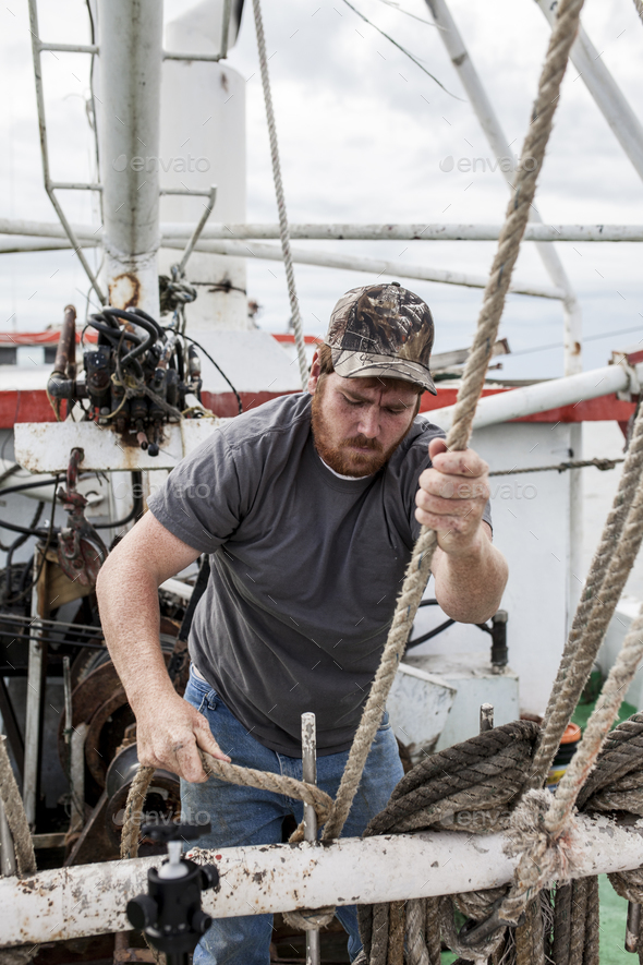 Commercial fisherman working on the deck of a ship Stock Photo by wollwerth