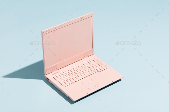 Retro pink laptop on a pastel blue background. Stock Photo by photocreo