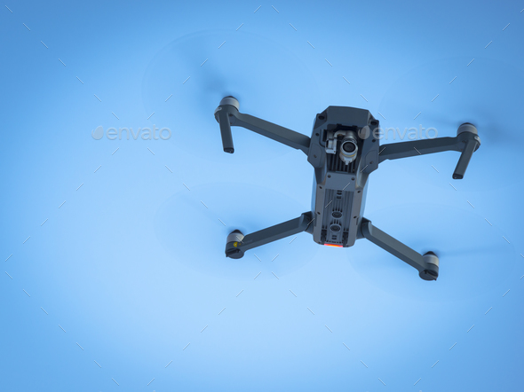 Drone flying in the blue sky, unmanned copter flight Stock Photo by gargantiopa