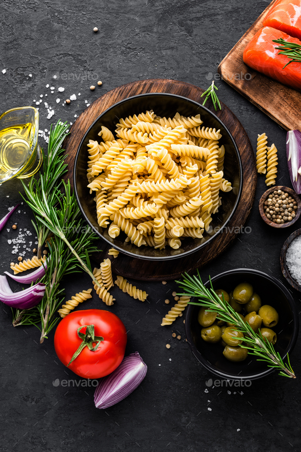 Pasta, salmon fish and ingredients for cooking on black background, top view. Italian food Stock Photo by sea_wave