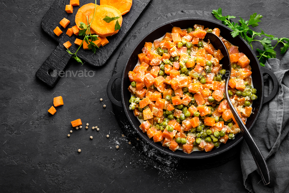 Carrot braised with fresh green peas in creamy milk sauce in stewpan, vegetable saute Stock Photo by sea_wave