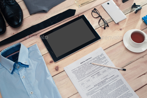 Rental contract and business accessories on wooden table. Stock Photo by Vladdeep