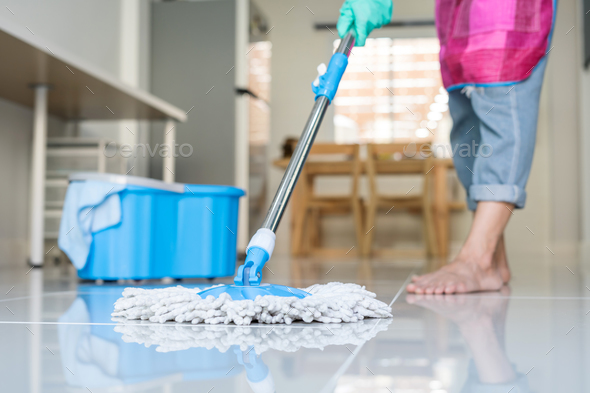 Young woman cleaning floor with mop and bucket Stock Photo by kitzstocker
