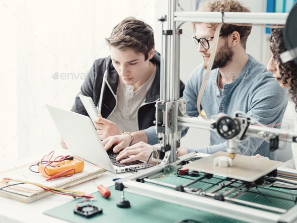 Group of students using a 3D printer and a laptop Stock Photo by stokkete