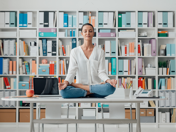 Woman practicing meditation on a desk Stock Photo by stokkete | PhotoDune