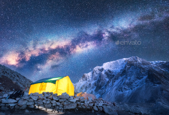 Milky Way, yellow glowing tent and mountains. Space Stock Photo by den-belitsky