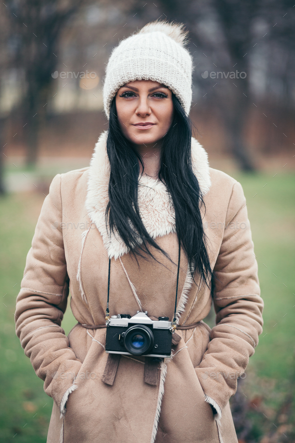 Female photographer taking pictures outdoors with a vintage camera Stock Photo by tommyandone