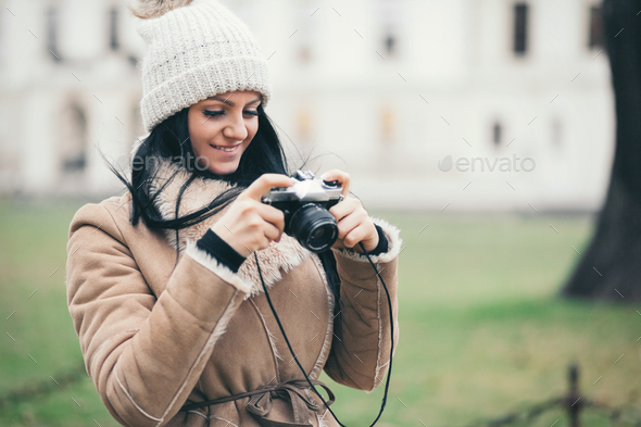 Female photographer taking pictures outdoors with a vintage camera Stock Photo by tommyandone