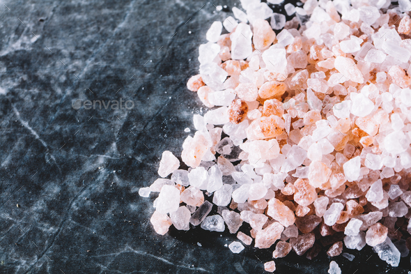 Grains of Himalayan salt on marble background. Stock Photo by photocreo