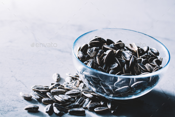 Little black sunflower seeds in a glass bowl. Stock Photo by photocreo