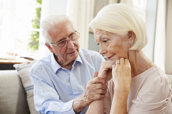 Senior Man Comforting Woman With Depression At Home Stock Photo by monkeybusiness