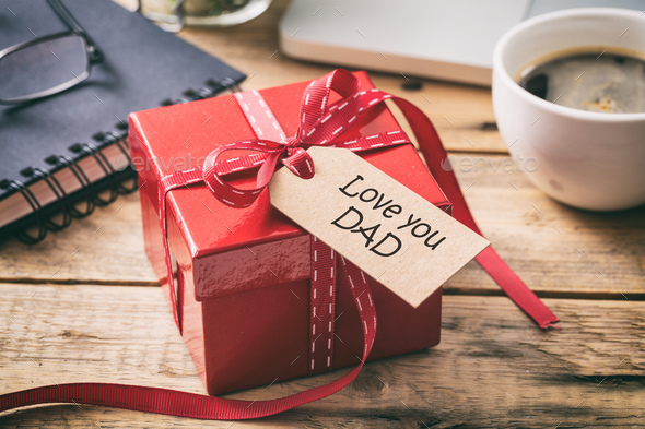 Father\'s day. Red gift box with love you dad tag, blur office desk background Stock Photo by rawf8