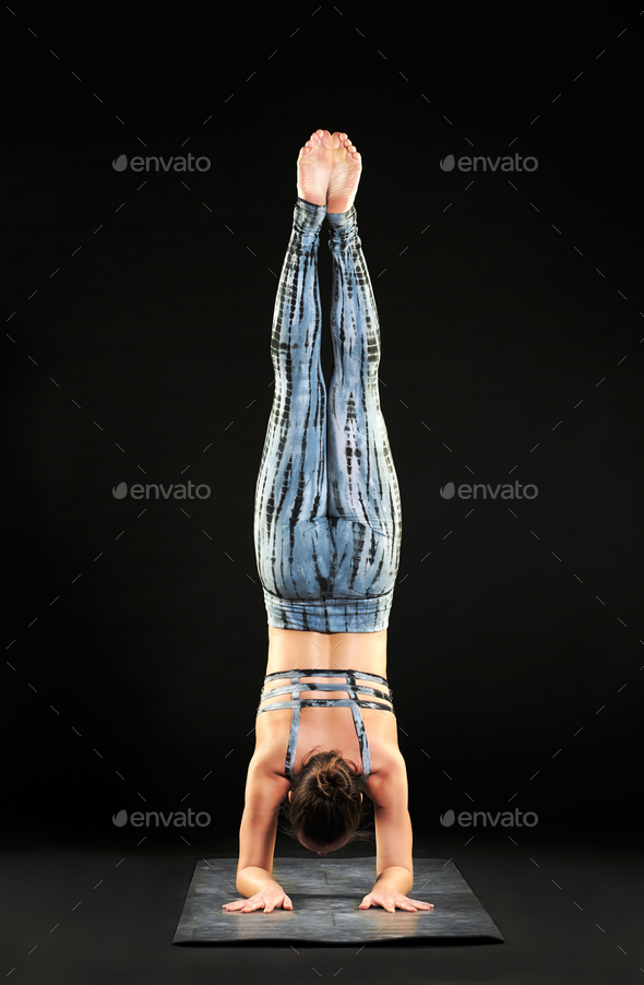 Woman demonstrating a forearm stand or pincha pose Stock Photo by Photology75