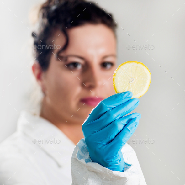 Food safety inspector testing fruit from the market Stock Photo by microgen