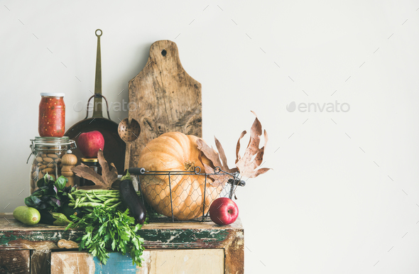 Autumn food ingredients and utensils over wooden cupboard, copy space Stock Photo by sonyakamoz