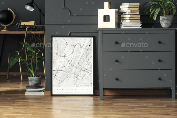 Map poster placed on the floor in real photo of dark grey room i Stock Photo by bialasiewicz