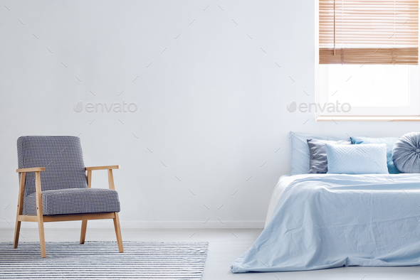 Patterned armchair on carpet in minimal bedroom interior with bl Stock Photo by bialasiewicz