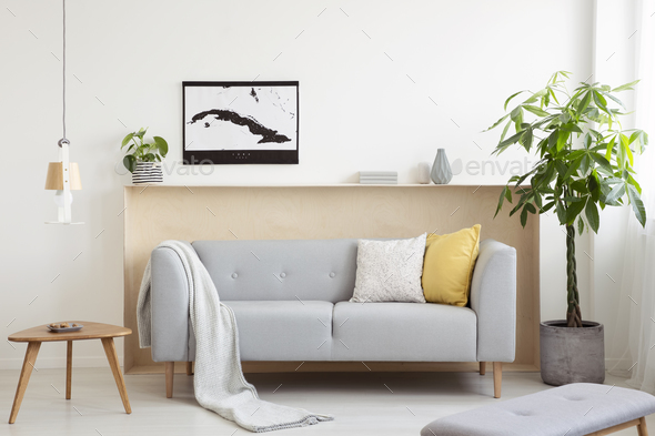 Grey lounge with cushions and blanket standing in real photo of Stock Photo by bialasiewicz
