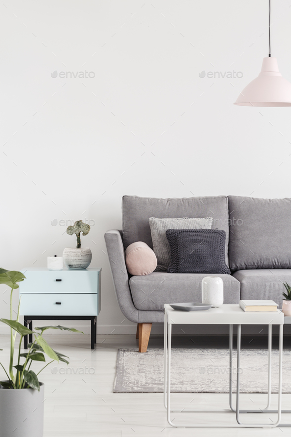 Cropped photo of a sofa next to small cabinet and coffee table i Stock Photo by bialasiewicz