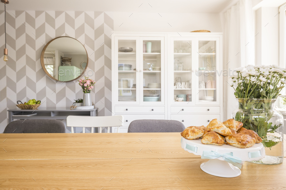 Croissants on wooden dining table in white apartment interior wi Stock Photo by bialasiewicz