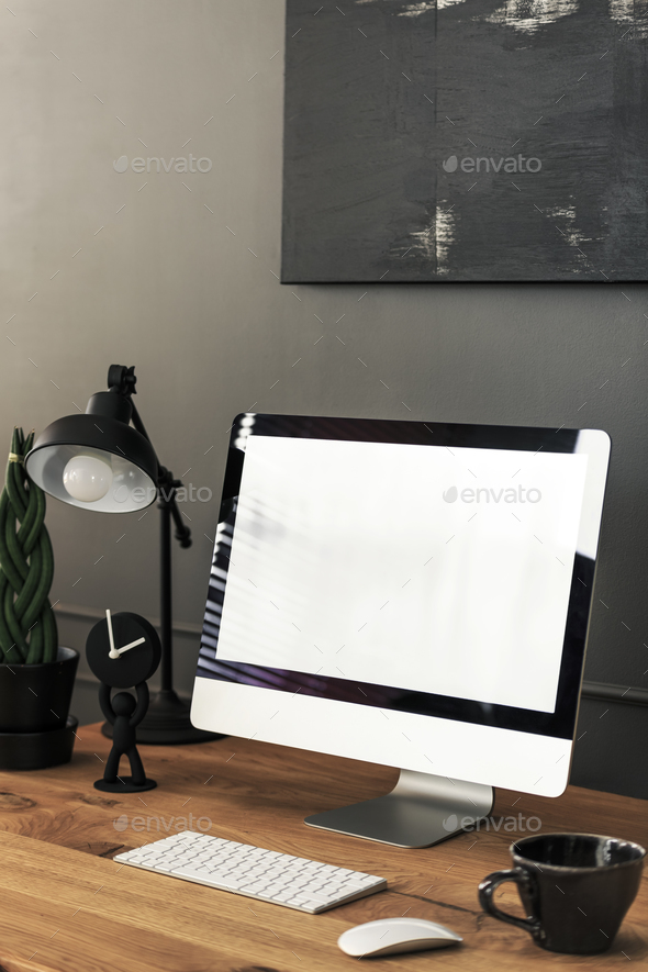Mockup of desktop computer on wooden desk with lamp in dark home Stock Photo by bialasiewicz