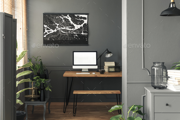 Real photo of dark open space living room interior with map post Stock Photo by bialasiewicz